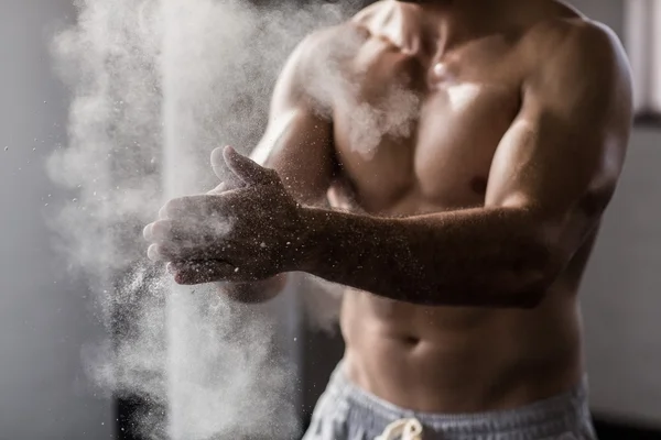 Muskulös man skakar krita bort hans händer — Stockfoto