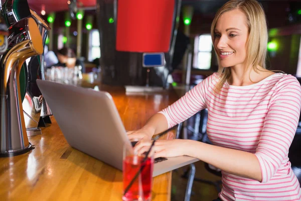 Mujer joven feliz usando el ordenador portátil — Foto de Stock