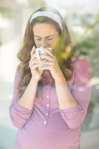 Frau nippt an Kaffee aus Tasse — Stockfoto