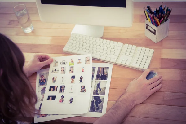 Hipster sosteniendo fotografías trabajando en el escritorio de la computadora — Foto de Stock