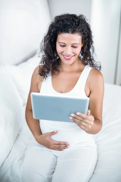 Atrakcyjna kobieta w ciąży za pomocą cyfrowego tabletu — Zdjęcie stockowe