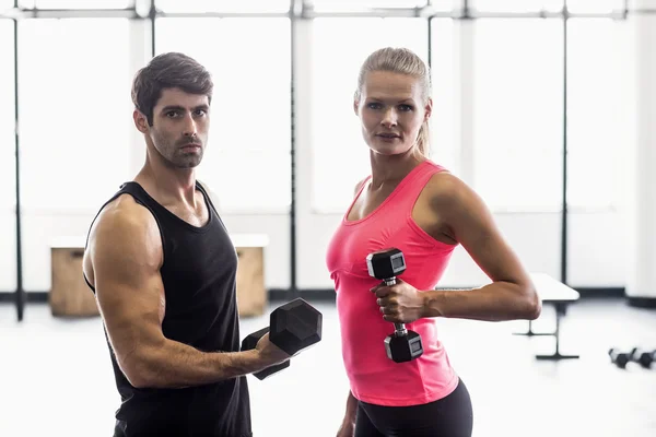 Casal exercício com halteres no ginásio — Fotografia de Stock