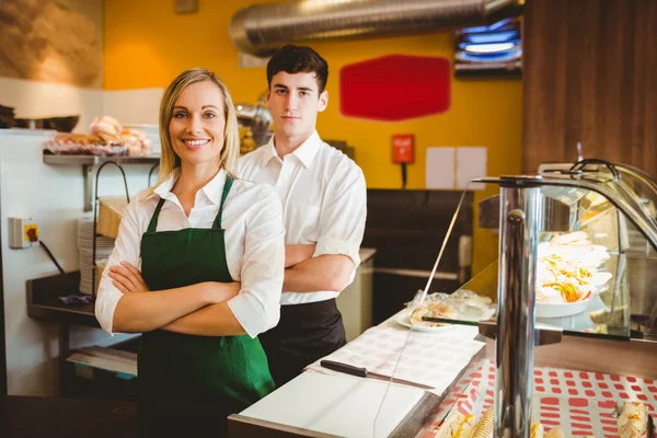 Confident coworkers by display cabinet — Stock Photo, Image