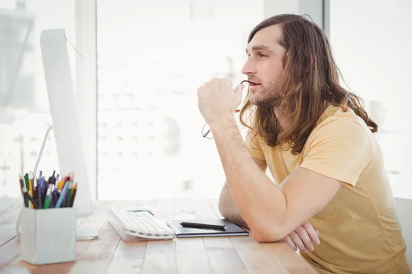 Thoughtful hipster at computer desk — Stock Photo, Image