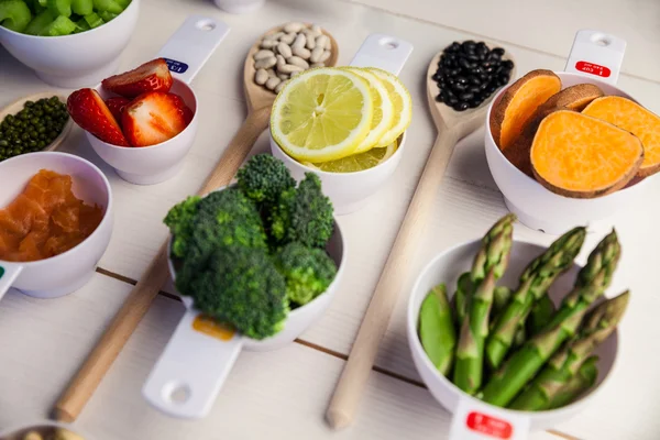 Gedeelte kopjes en lepels van gezonde ingrediënten — Stockfoto