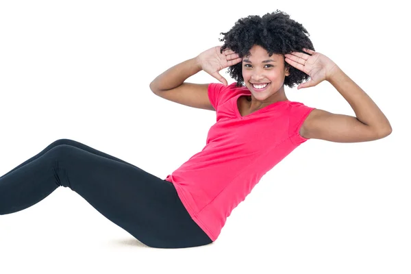 Portrait of young woman doing sit ups — Stock Photo, Image