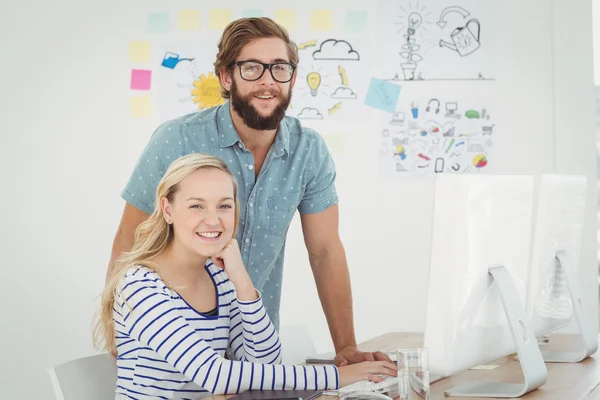 Portrait of smiling business people at computer desk — Stock Photo, Image