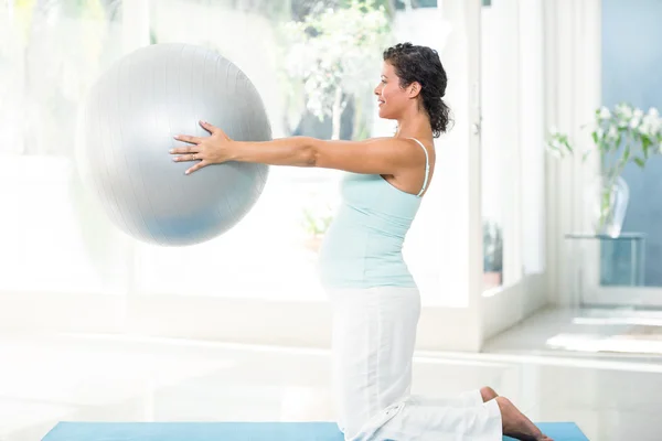 Беременная женщина держит мяч для упражнений — стоковое фото