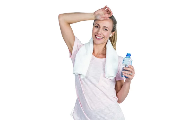 Sportowy kobieta dotyka czoło trzymając butelkę — Zdjęcie stockowe
