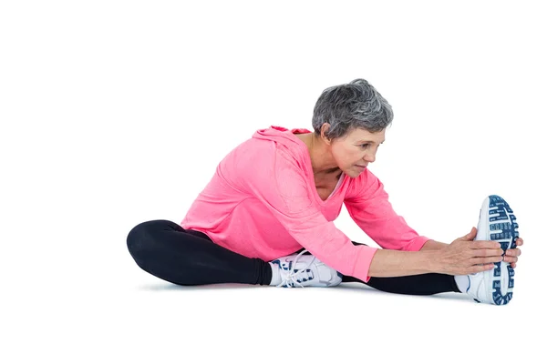 Mature woman touching toes while exercising — Stock Photo, Image