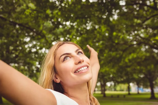 Fröhliche Frau mit erhobenen Armen im Park — Stockfoto