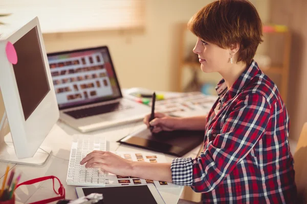 Fokussierte Fotografin sucht Bilder auf ihrem Computer — Stockfoto