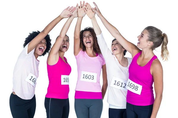 Atletas sonrientes poniendo sus manos juntas con los brazos levantados — Foto de Stock