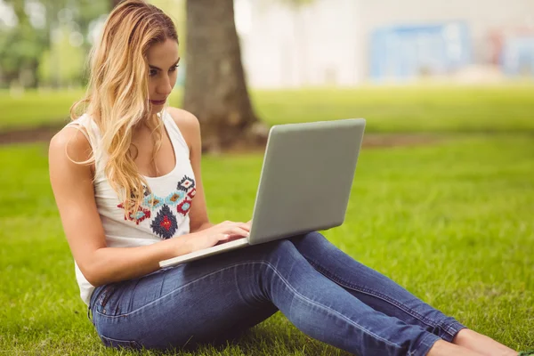 Pewnie kobieta korzysta z laptopa w parku — Zdjęcie stockowe