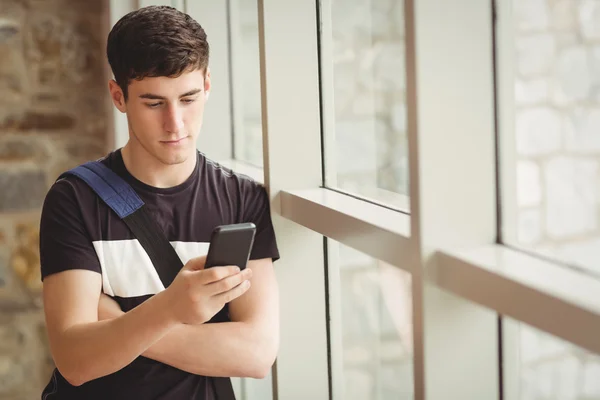 Manlig student med mobiltelefon i college — Stockfoto