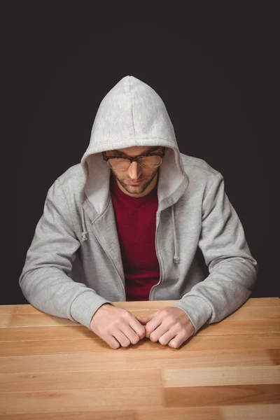 Homem com camisa com capuz sentado na mesa no escritório — Fotografia de Stock