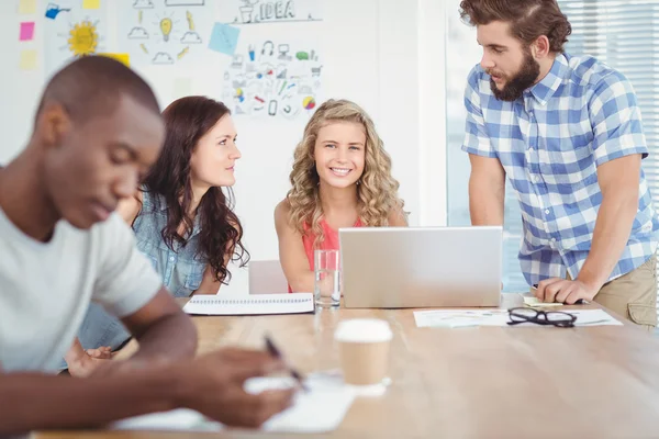 Portrait of smiling woman with coworkers working at desk — Stock Photo, Image
