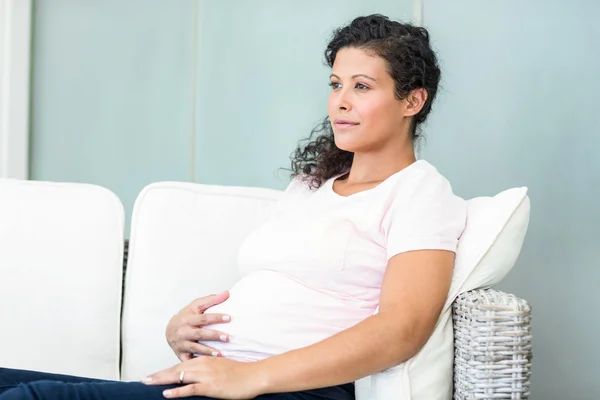 Glückliche Frau auf Sofa im Wohnzimmer — Stockfoto