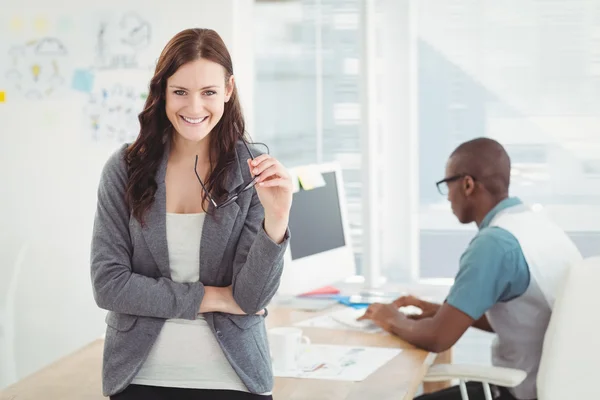 Portrait of smiling businesswoman holding eyeglasses — Stock Photo, Image