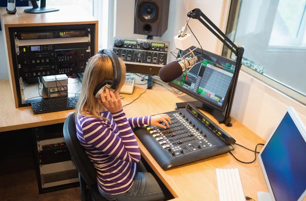 Host de rádio feminino operando misturador de som — Fotografia de Stock