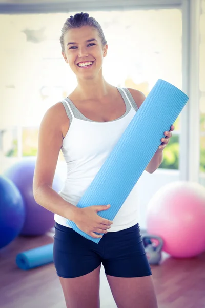 Portret van een vrouw die lacht terwijl yoga mat — Stockfoto