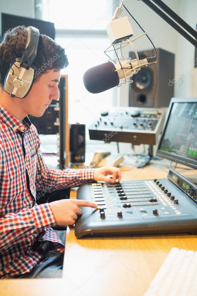 Radio host wearing headphones operating sound mixer — Stock Photo