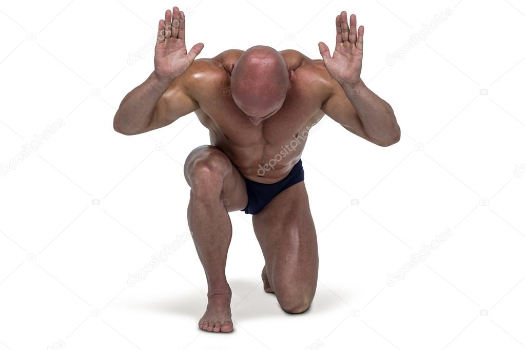 Muscular man bending on knee with arms raised — Stock Photo © Wavebreakmedia 84919072