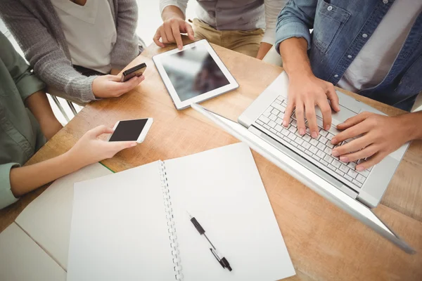 Mid section of business people using laptop and smartphones — Stock Photo, Image