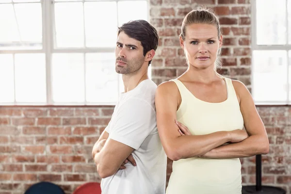 Fit casal com braços cruzados na sala de exercícios brilhante — Fotografia de Stock