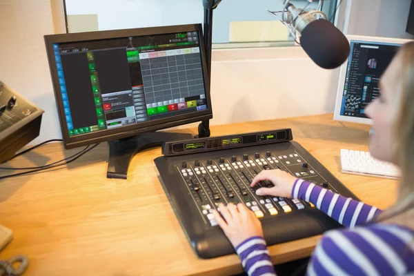 Anfitrión de radio femenino frente al mezclador de sonido de funcionamiento de pantalla — Foto de Stock