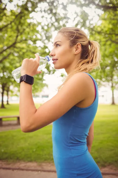 Gülümseyen jogging yapan kadın içme suyu — Stok fotoğraf