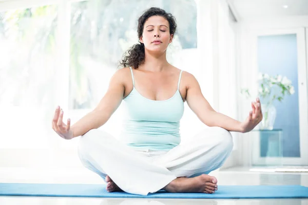 Femme enceinte faisant du yoga avec les yeux fermés sur le tapis d'exercice — Photo