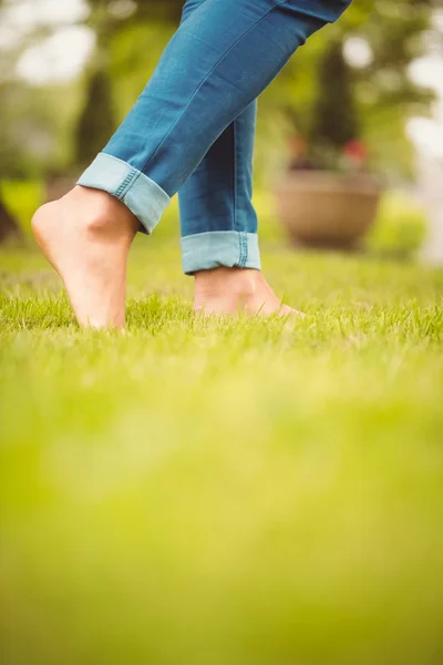 Baixa seção de mulher andando na grama verde — Fotografia de Stock