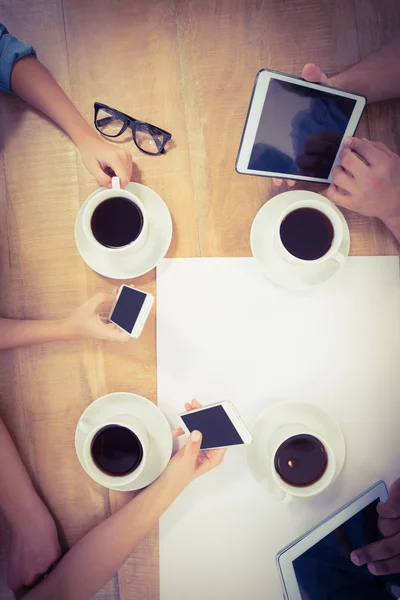 Overhead view of people using technology at desk — Stock Photo, Image