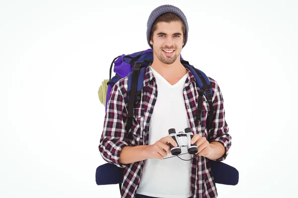 Happy hipster wearing backpack holding binoculars — Stock Photo, Image