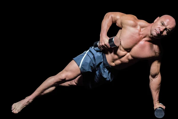 Retrato del hombre musculoso haciendo ejercicio con pesas en tablón lateral — Foto de Stock