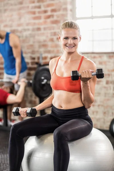 Muscular sorrindo mulher fazer alguns levantamento de peso — Fotografia de Stock