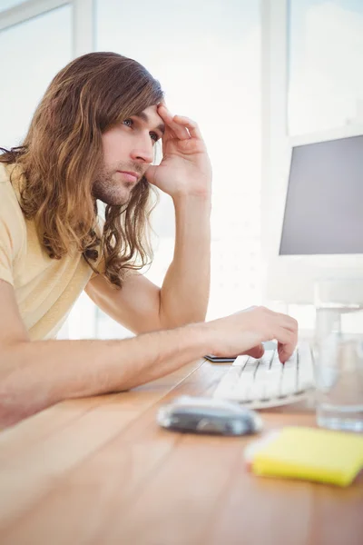 Endişeli hipster bilgisayarda çalışarak — Stok fotoğraf