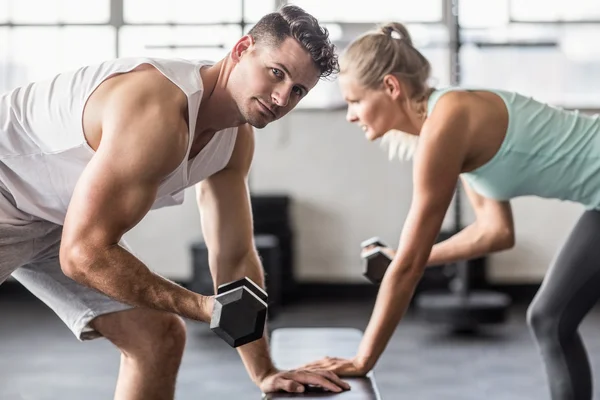 Pareja haciendo ejercicio con pesas en el gimnasio —  Fotos de Stock