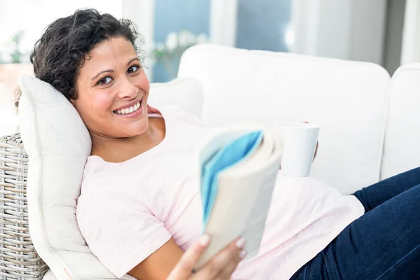 Zwangere vrouw met boek houden van koffie — Stockfoto