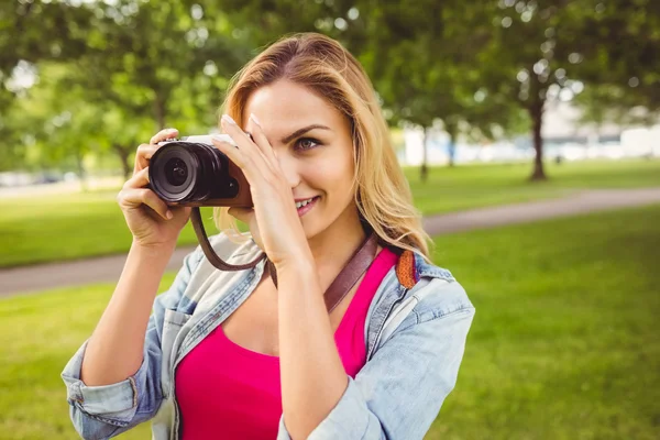 Smiling woman taking picture with camera — Stock Photo, Image