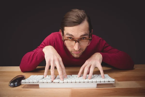 Hombre con anteojos escribiendo en el teclado de la computadora — Foto de Stock