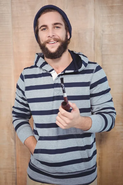 Joyeux hipster avec chemise à capuche tenant tuyau fumeur — Photo