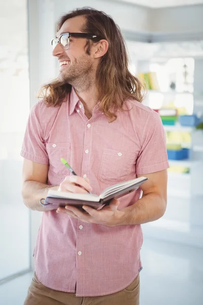 Happy hipster håller boken och penna — Stockfoto