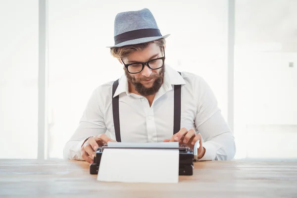 Hipster con anteojos y sombrero trabajando en máquina de escribir —  Fotos de Stock