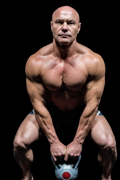 Porträt eines muskulösen Mannes, der mit Kettlebells trainiert — Stockfoto