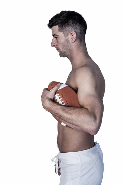 Vista lateral del hombre sin camisa sosteniendo la pelota — Foto de Stock