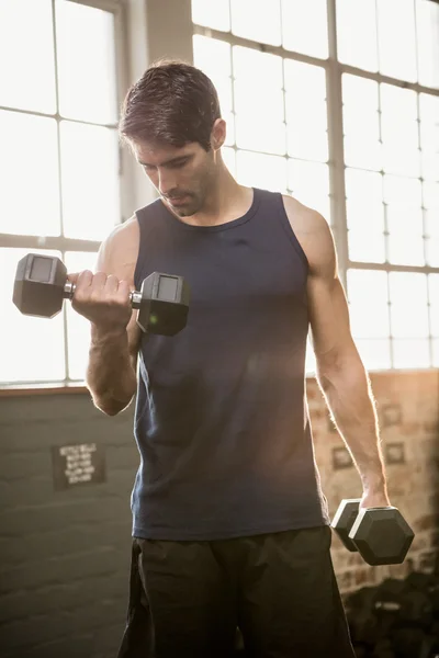 Man lifting dumbbell while looking down — Stock Photo, Image