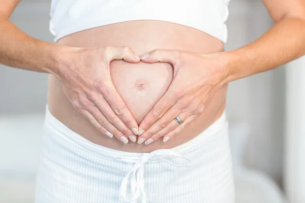 Midsection de mulher fazendo coração na barriga — Fotografia de Stock