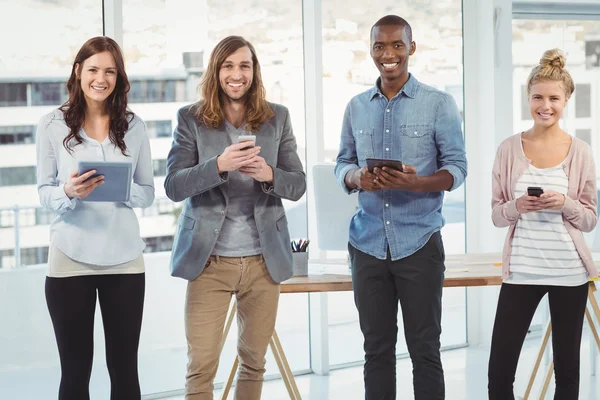 Portret van vrolijke bedrijf team met behulp van technologie — Stockfoto